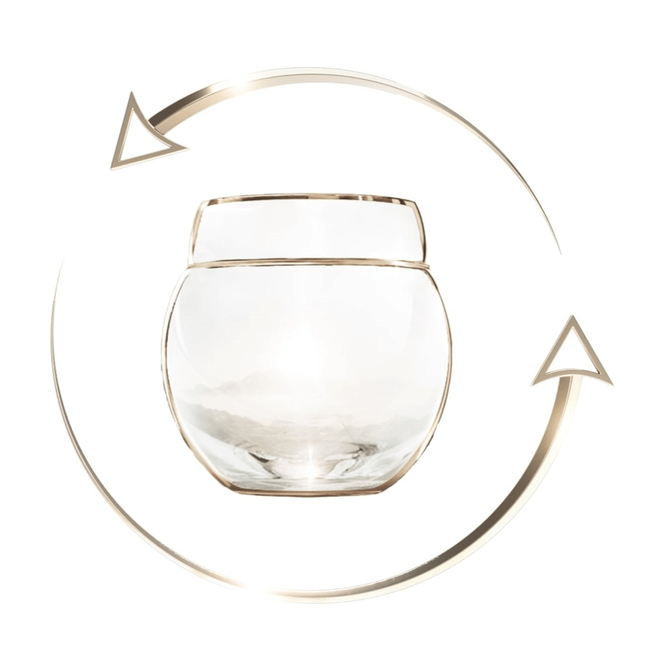 An empty, clear glass cream jar, rimmed in gold, is surrounded by two golden arrows symbolizing recycling, on a pure white background.
